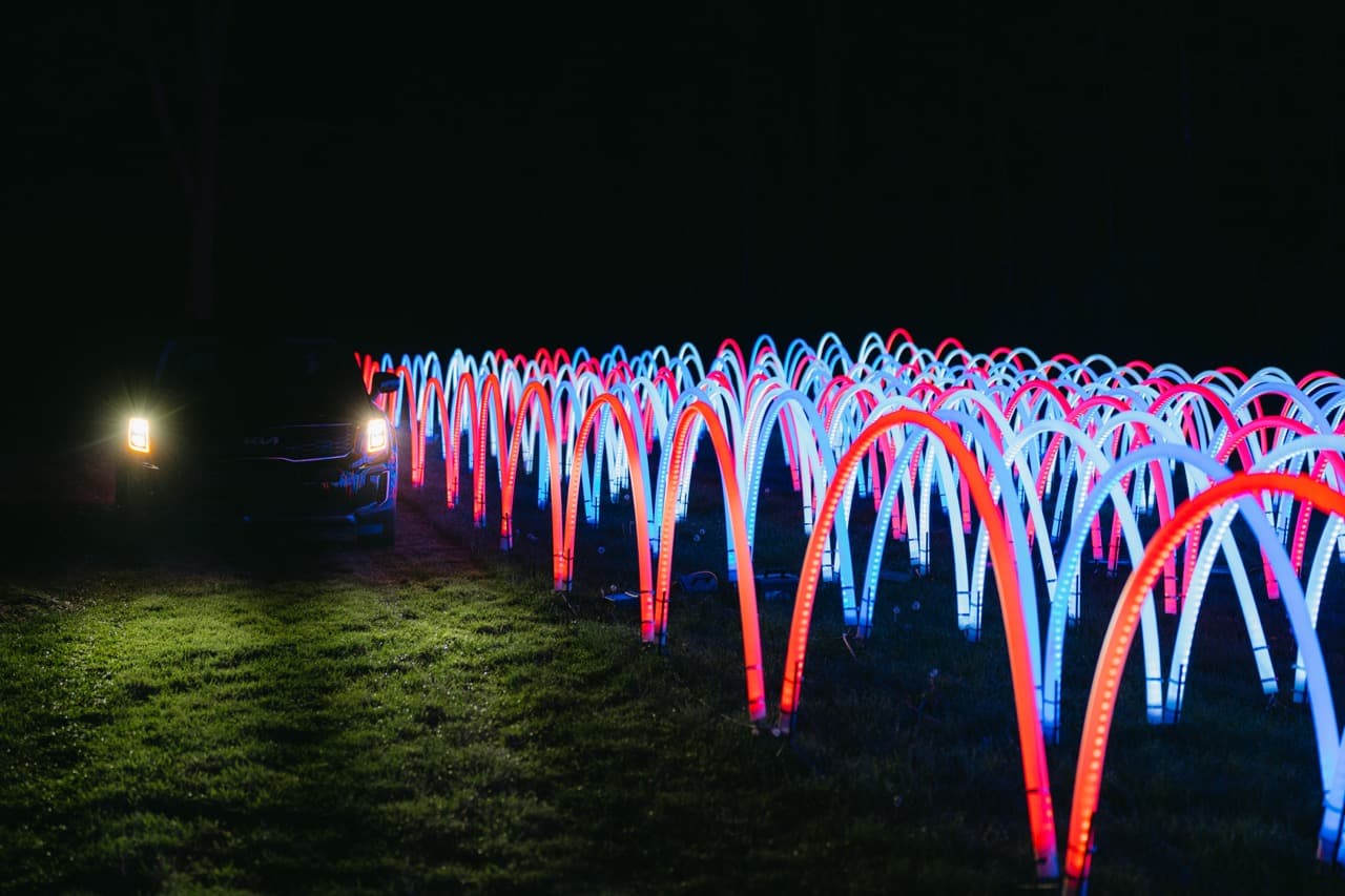 Colorful LED light arcs bouncing across field in red, blue and white patterns